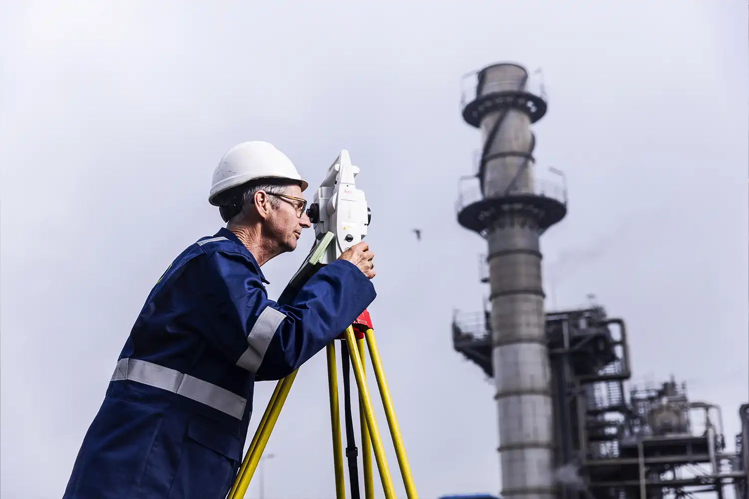 Landmeter voert industriële hoogtemetingen en positioneringsmetingen uit met geodesie apparatuur